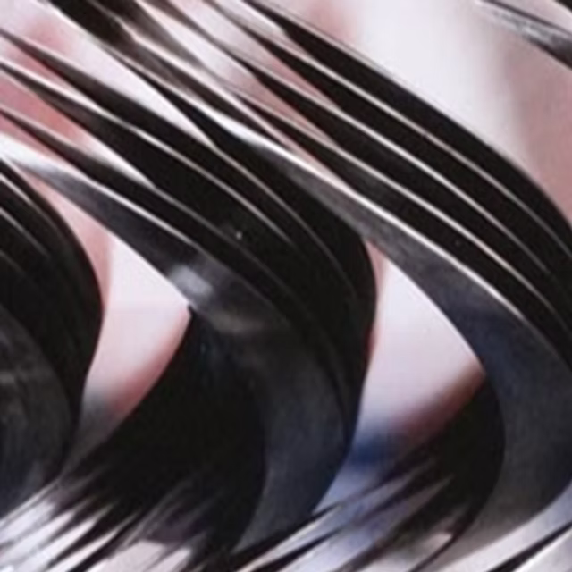 Helical fleshing blades for a leather fleshing machine